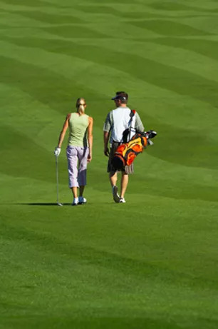 Zwei Menschen laufen über Golfplatz